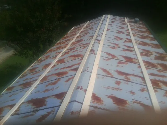 Rusted metal roof panels with new wood purlins before replacement — Storm Damage Roof Repair in Shohola by Roofing Brothers