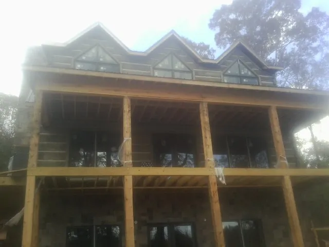 Dormers and porch framing on a large log home under construction — Roof Coating work by our crew in Shohola