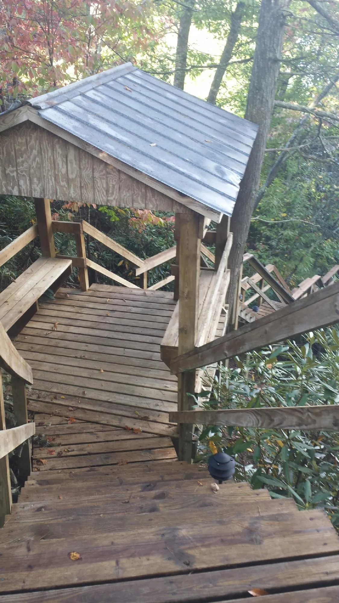 Metal roofed shelter over wooden steps on a wooded walkway — Skylight Repair & Installation work by our crew in Shohola